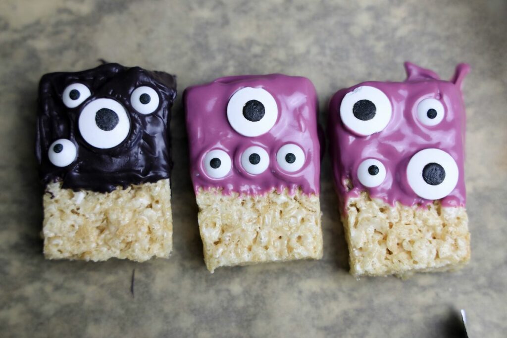 Monster rice krispie treats on a parchment paper.