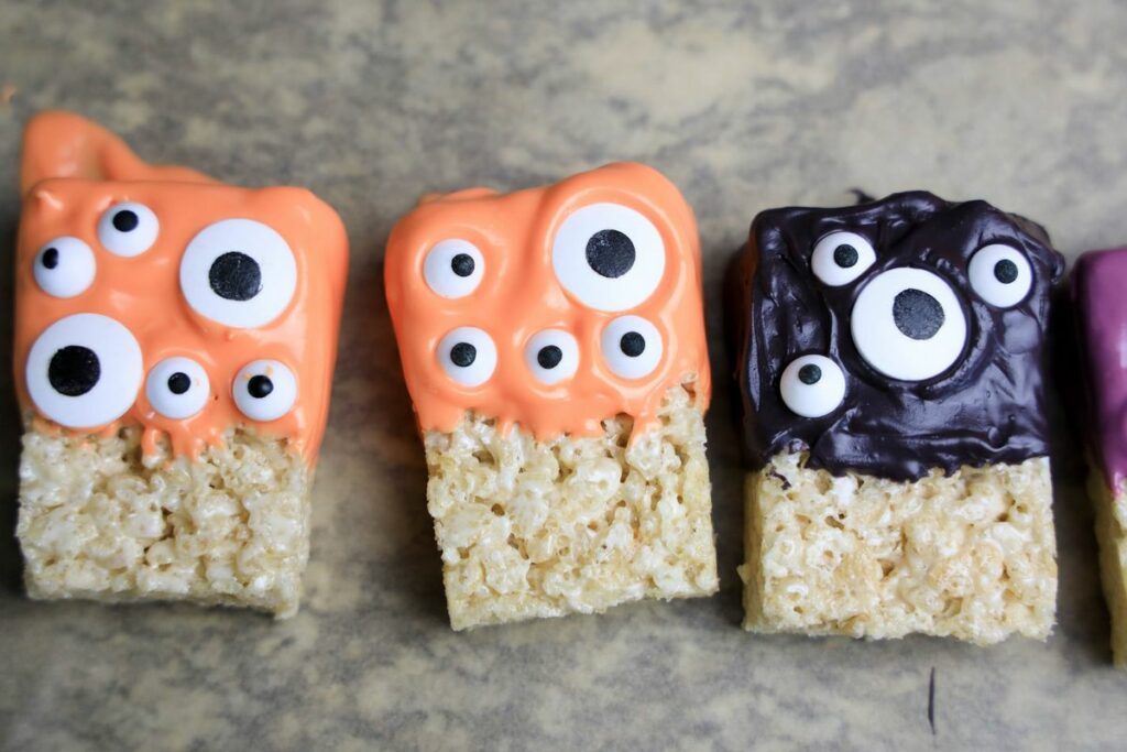 Monster rice krispie treats on a parchment paper.