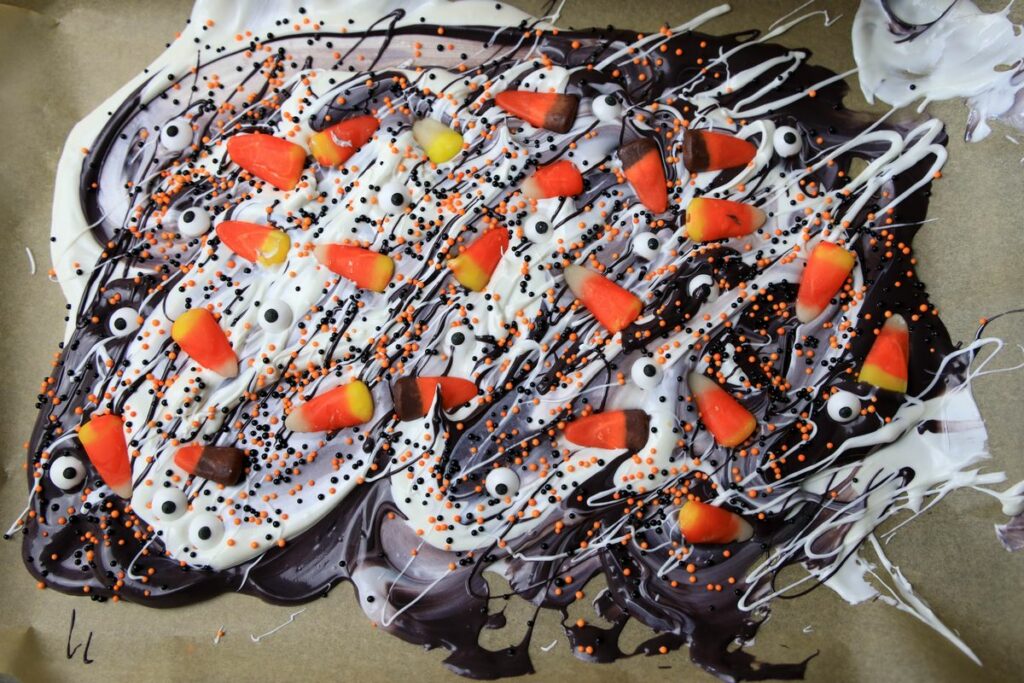 Black and white candy bark with sprinkles, candy eyes, and candy corn.