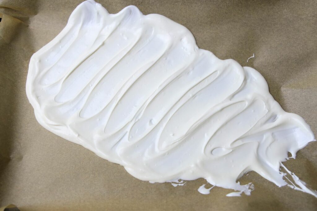 White candy melts on parchment paper.